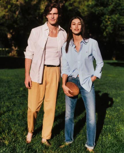 A male and female model wears an Oxford shirt and pants, new from Tommy Hilfiger.