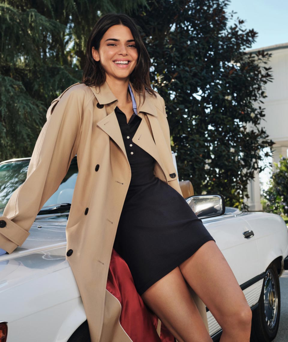 Supermodel Kendall Jenner wears a polo dress and trench coat, new from Tommy Hilfiger.