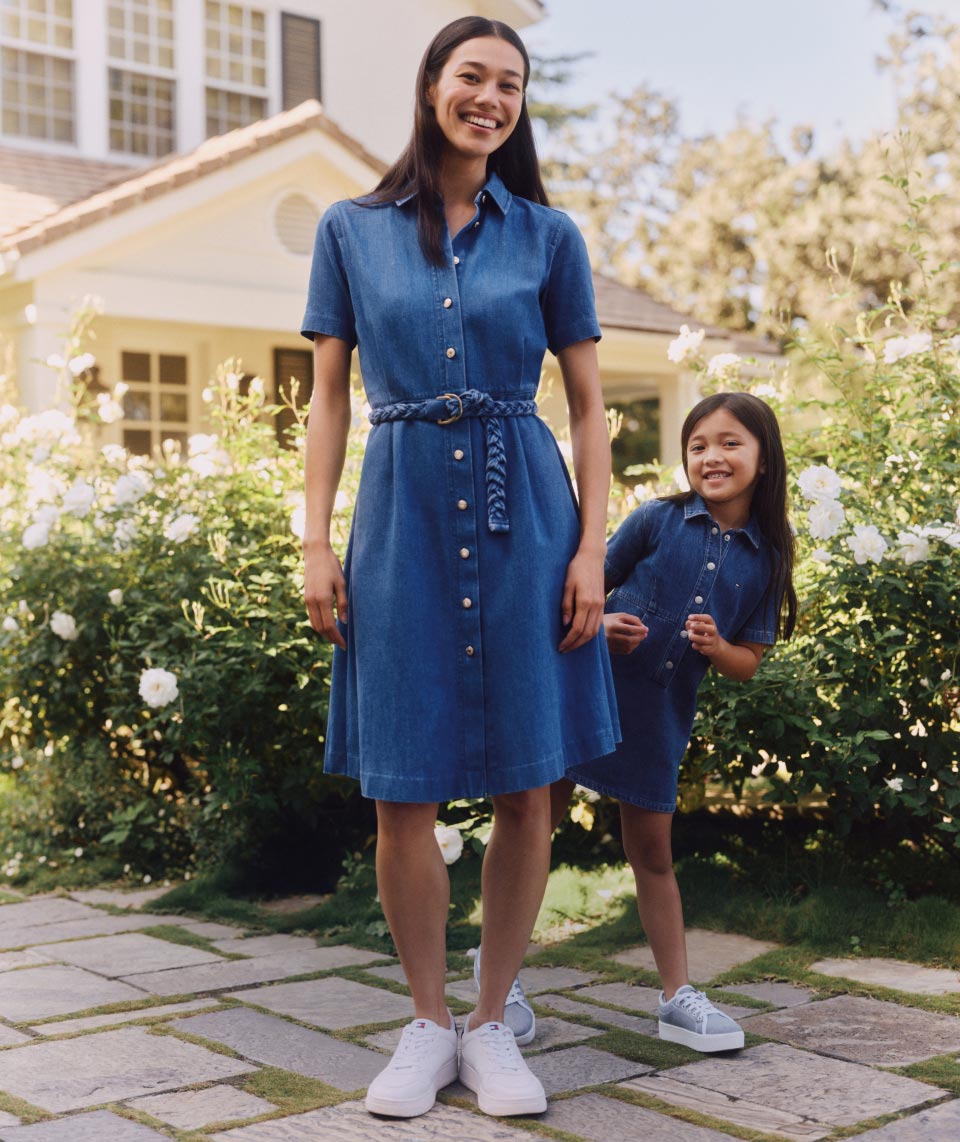 A mother and daughter wear matching denim dresses, new for spring from Tommy Hilfiger.