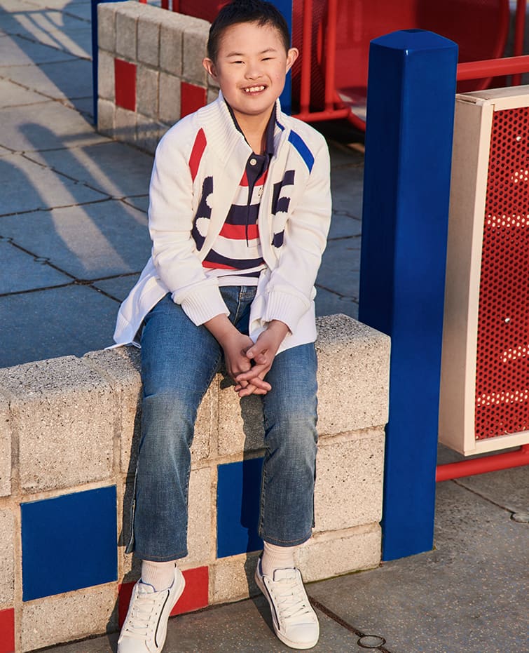 SUMMER SHOUT OUT Fun colors and graphics, new for kids from Tommy Adaptive. Boy model wearing striped polo, open-front sweater and jeans, all designed with hidden features that make dressing easier.