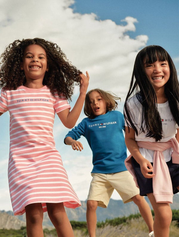 Two boy models wear new season apparel and accessories for summer from Tommy Hilfiger.