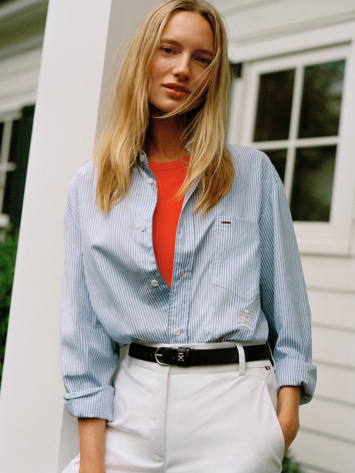 A female model wears an Oxford and pants, new from Tommy Hilfiger.