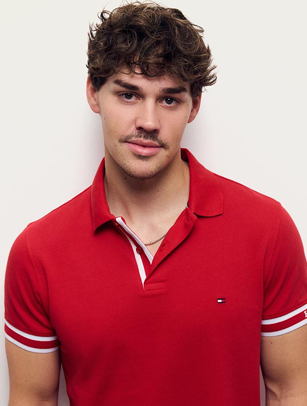 Noah Beck wears a red-and-white check button-down shirt, new from Tommy Hilfiger.