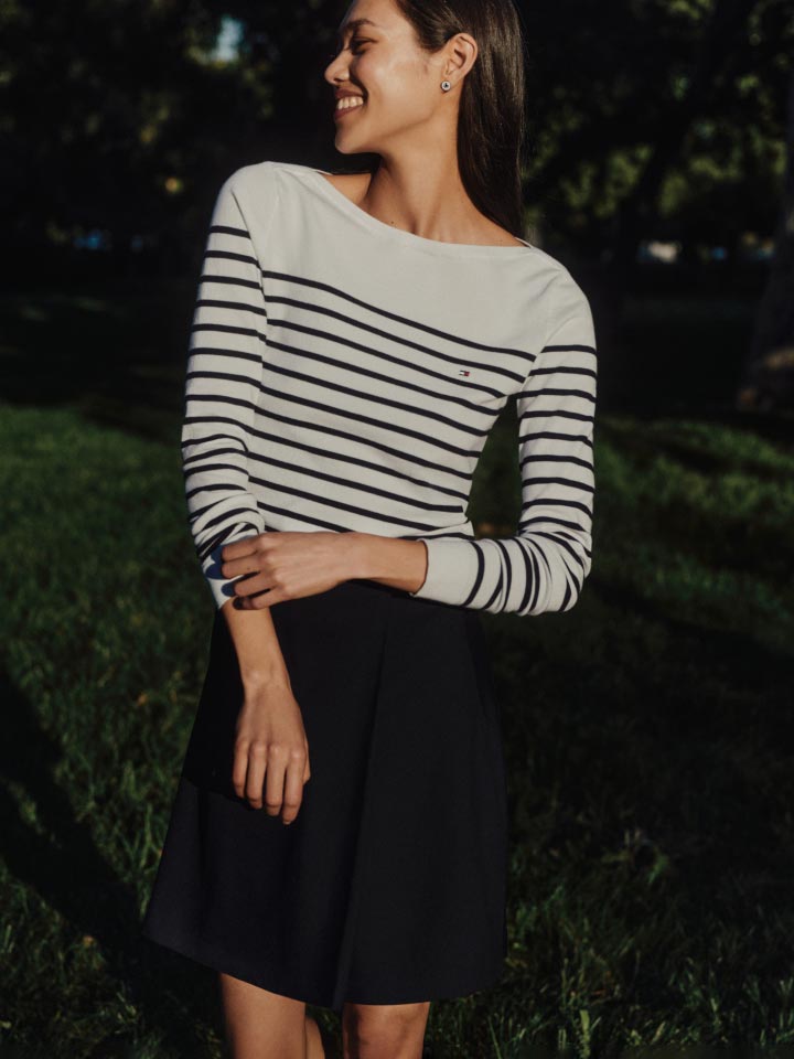 A female model wears a striped sweater, new from Tommy Hilfiger.
