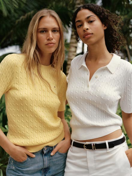 Two female models wear short sleeve summer sweaters from Tommy Hilfiger.