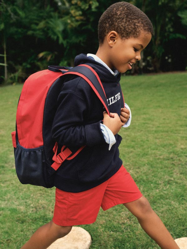 A boy wears summer clothes and accessories from Tommy Hilfiger.