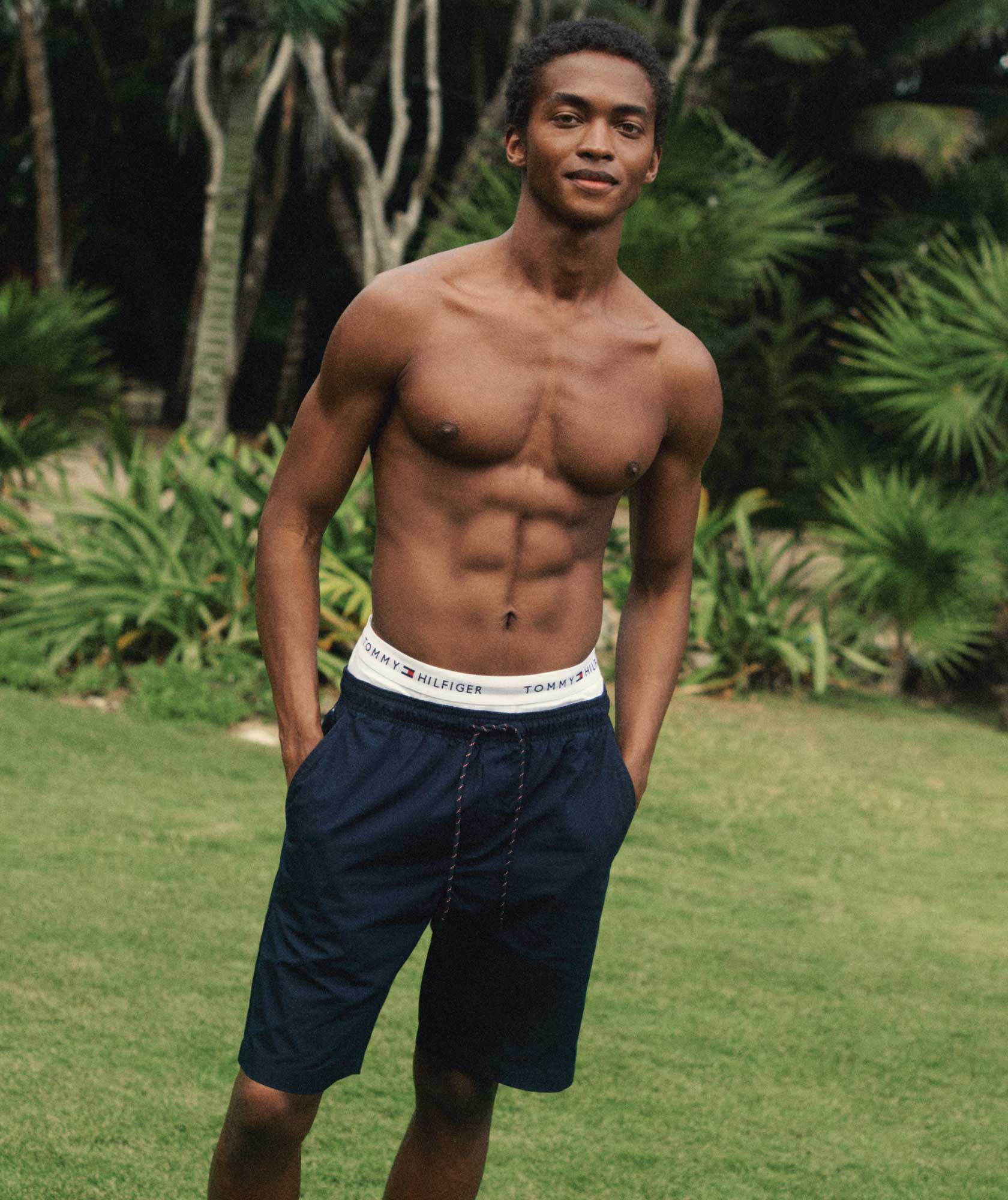 A male model wears a pair of Tommy Hilfiger shorts.