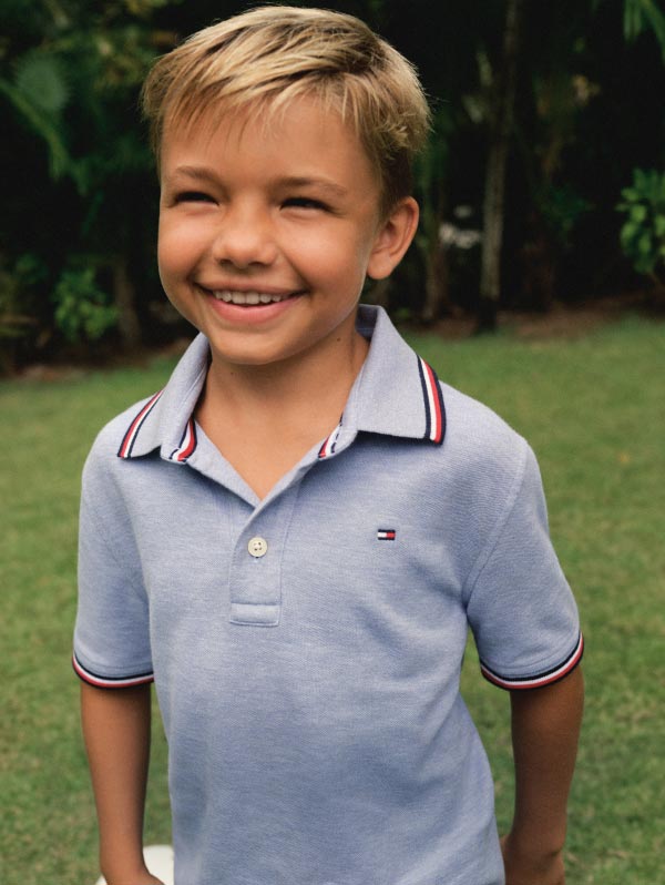 A boy wears a blue tipped polo, new from Tommy Hilfiger kids'.