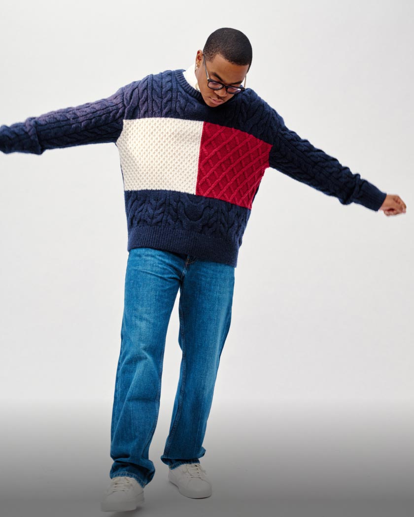 Michael Rainey wears a cable knit wool-blend sweater and medium wash jeans for the Tommy Hilfiger Fall Fashion Show.