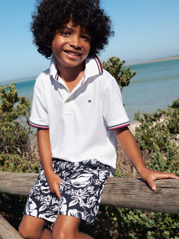 Kid sitting on a fence wearing Tommy Hilfiger polo shirt