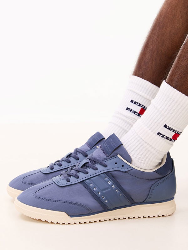 Mans legs wearing Tommy Hilfiger sneakers and socks