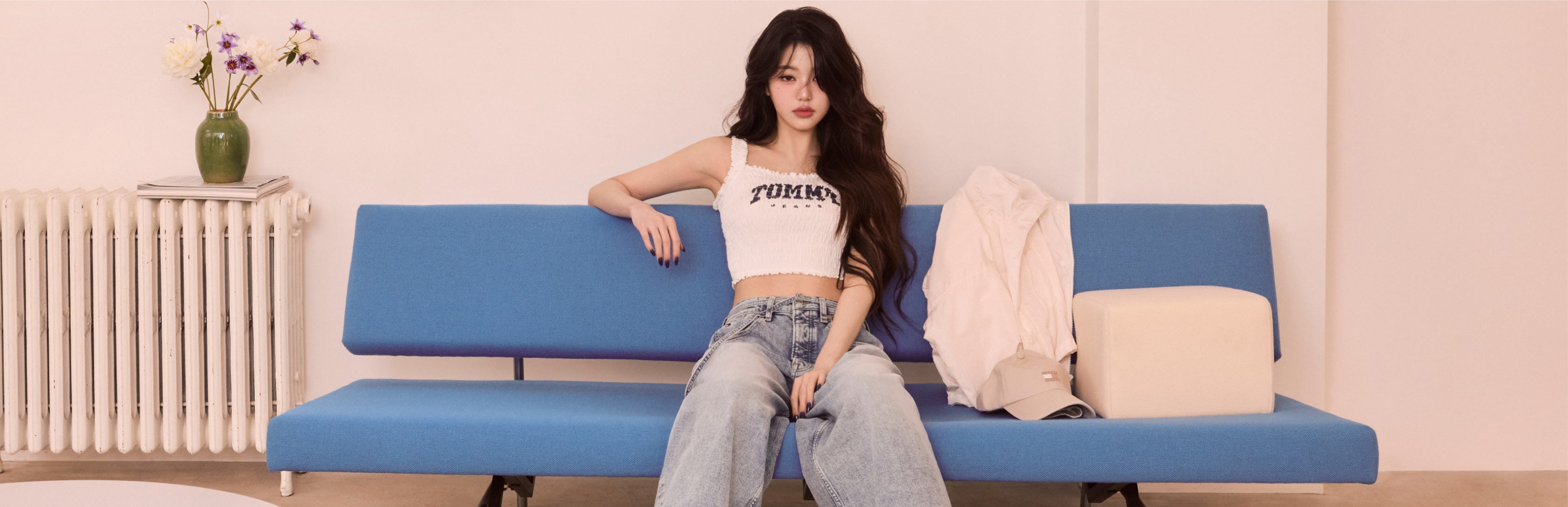Won Young assis sur un canapé habillé en Tommy Girl par Tommy Hilfiger