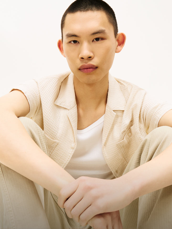 Man sitting wearing Tommy Jeans camp collar unbuttoned
