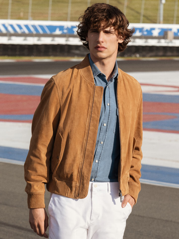 Man walking down the racetrack dressed in Tommy Hilfiger race jacket and and straight fit pants