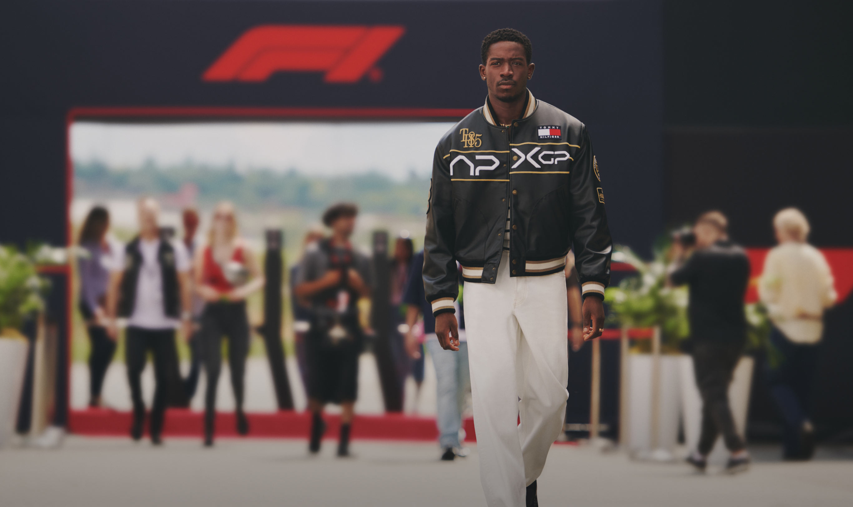 Tommy Hilfiger X F1 The Movie with Damson Idris walking on the racetrack wearing APXGP race jacket