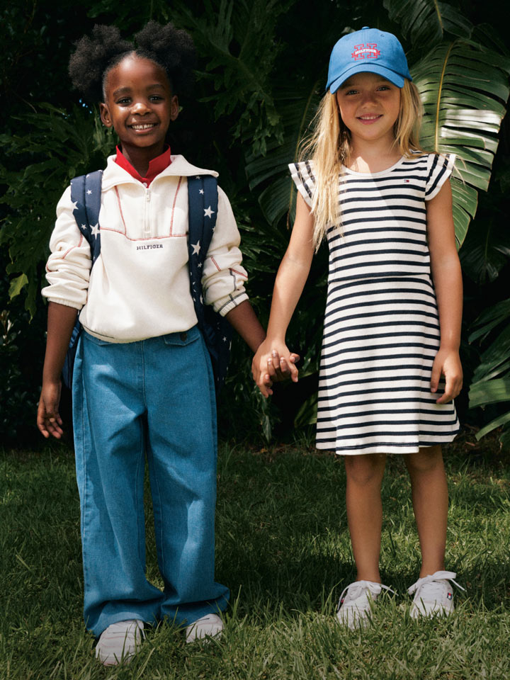 Two girls holding hands dressed in Tommy Hilfiger ready for school