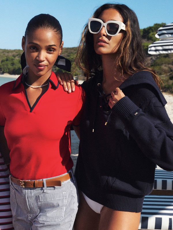 Two girls dressed in Tommy Hilfiger on the beach with arms around each other
