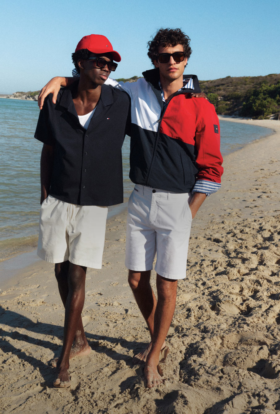 Two guys on the beach dressed in Tommy Hilfiger with arms around each other