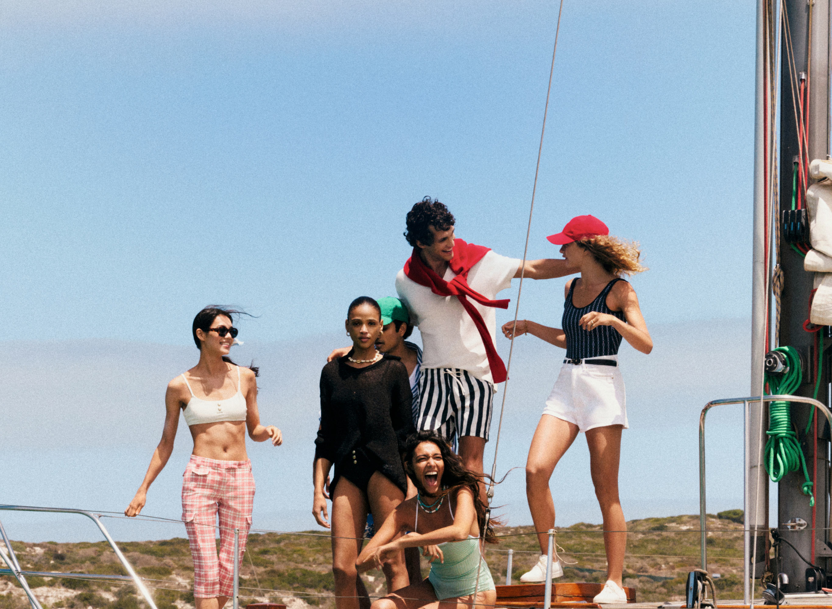 Group on a beach near the water dressed in classic Tommy Hilfiger red white and blue