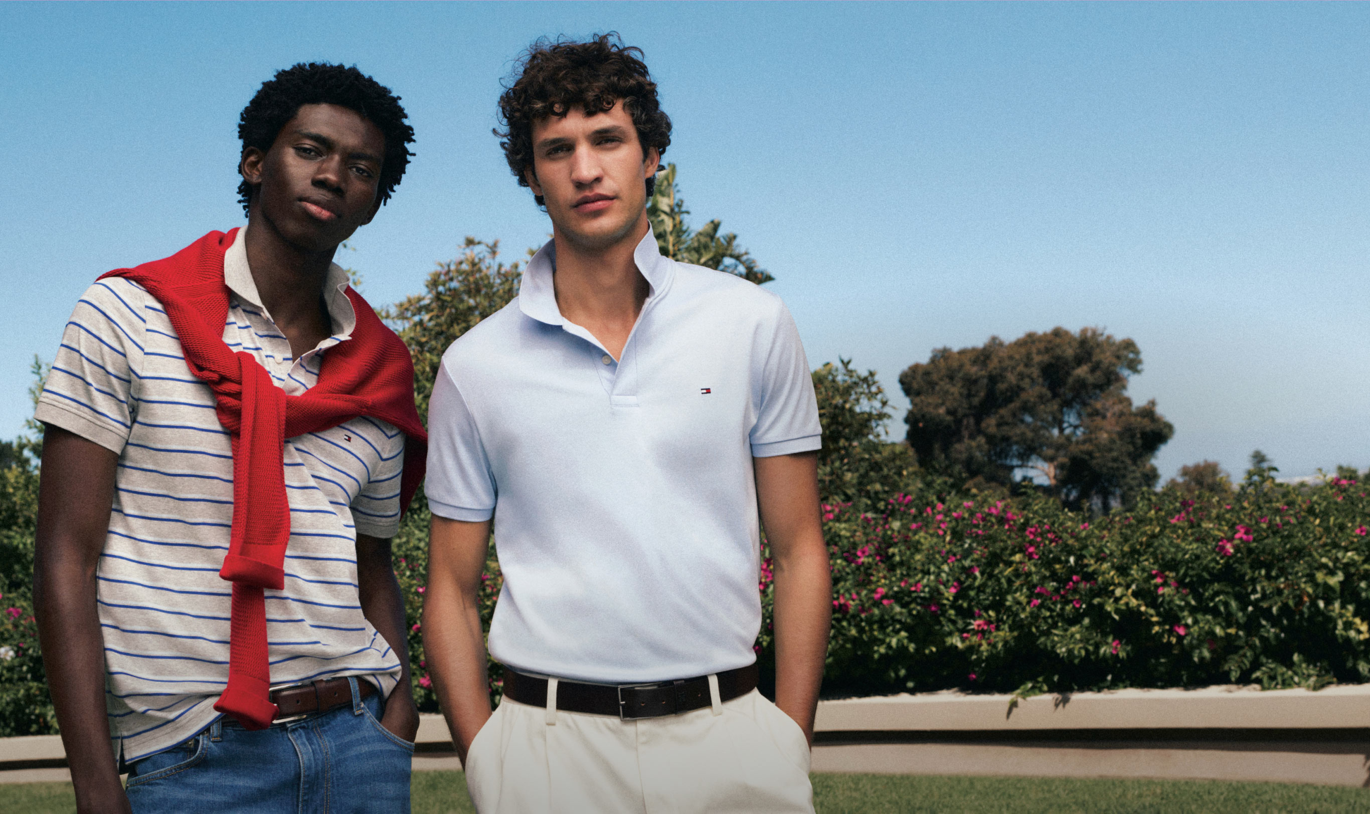Two guys wearing Tommy Hilfiger Polo shirts standing with hands in their pockets