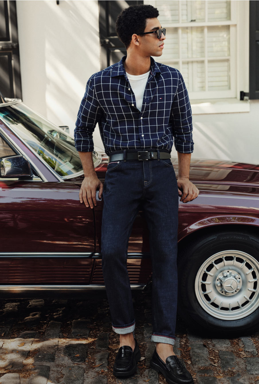 A men standing by a car waering a full Tommy Hilfiger outfit
