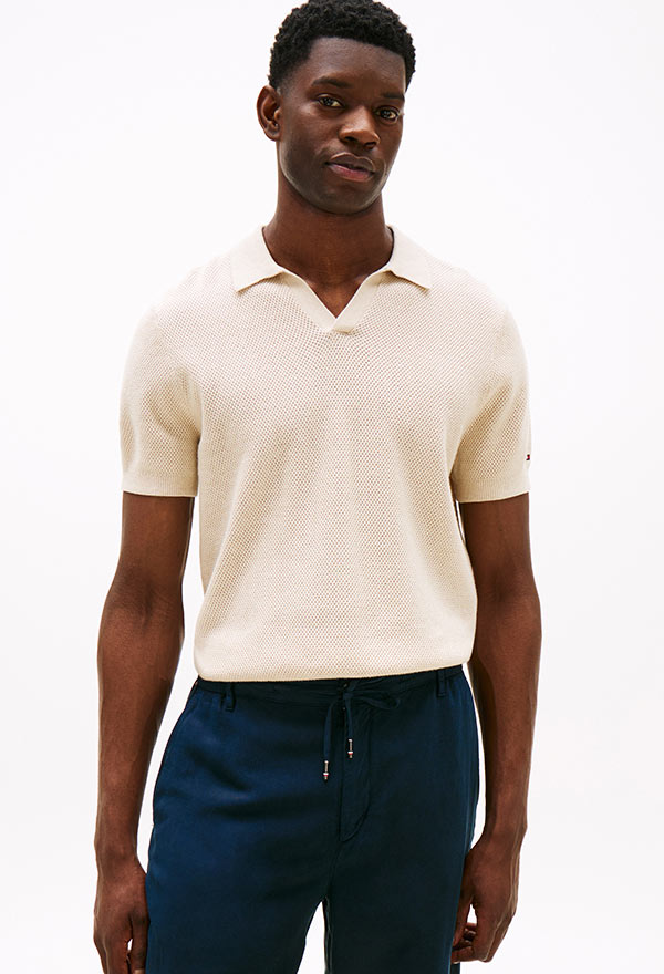 Model wearing a Tommy Hilfiger sweater polo, posed against a white background.