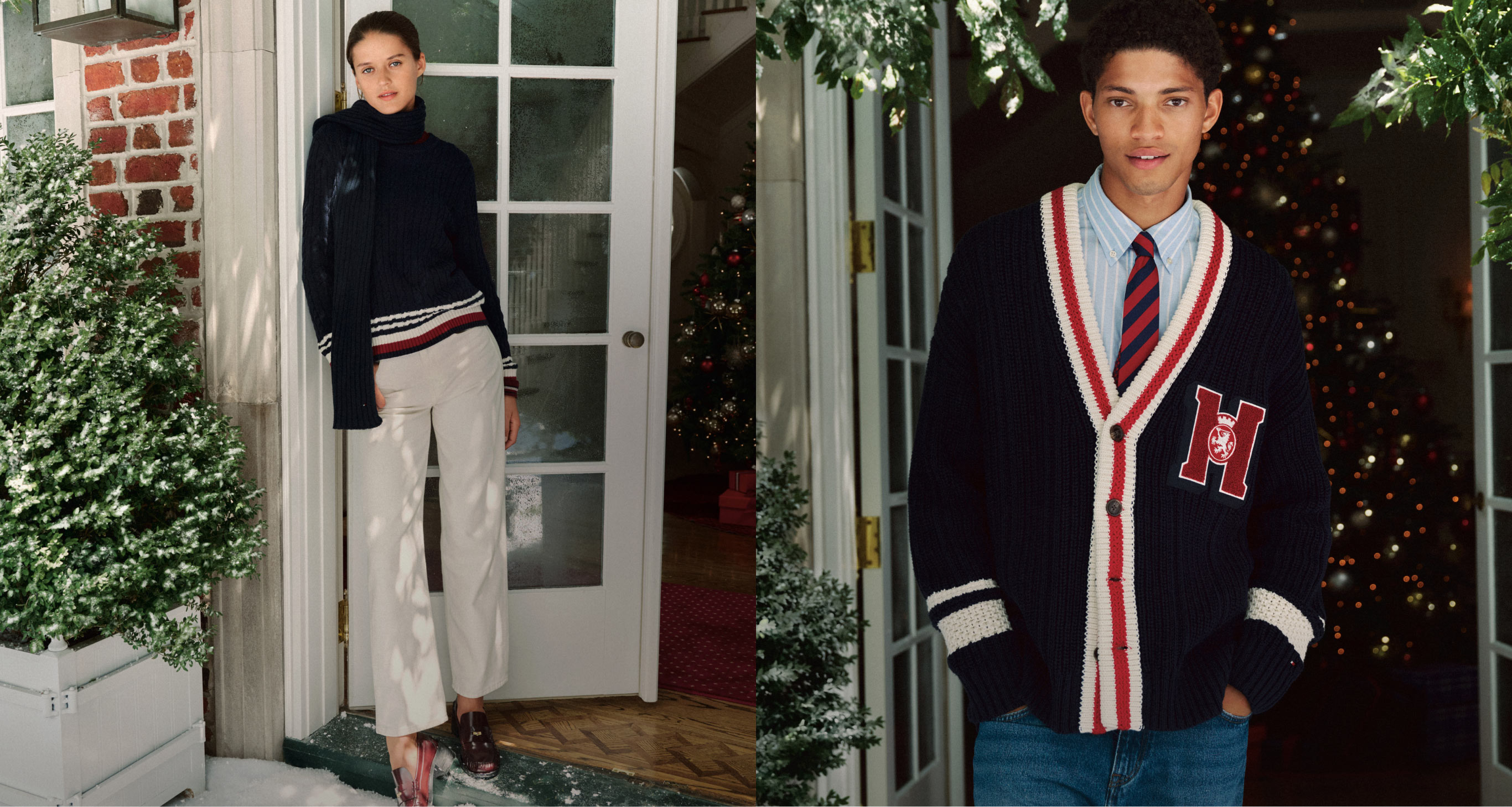Two models in Tommy Hilfiger looks--one wearing a navy zip sweater over a turtleneck with cream wide-leg trousers, the other in a navy varsity cardigan with red “H” patch, striped trim, collared shirt, and tie. They stand by a brick townhouse entry decorated with greenery and string lights.