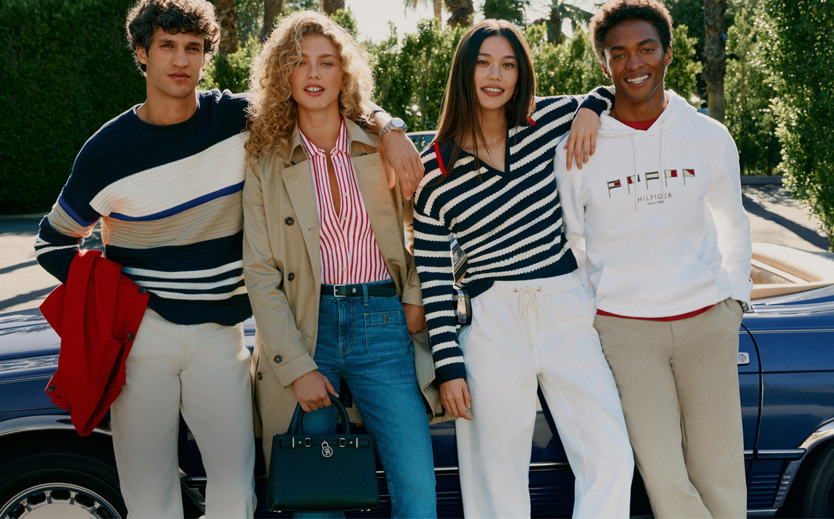 Image of a group of four models standing outdoors in casual Tommy Hilfiger outfits.