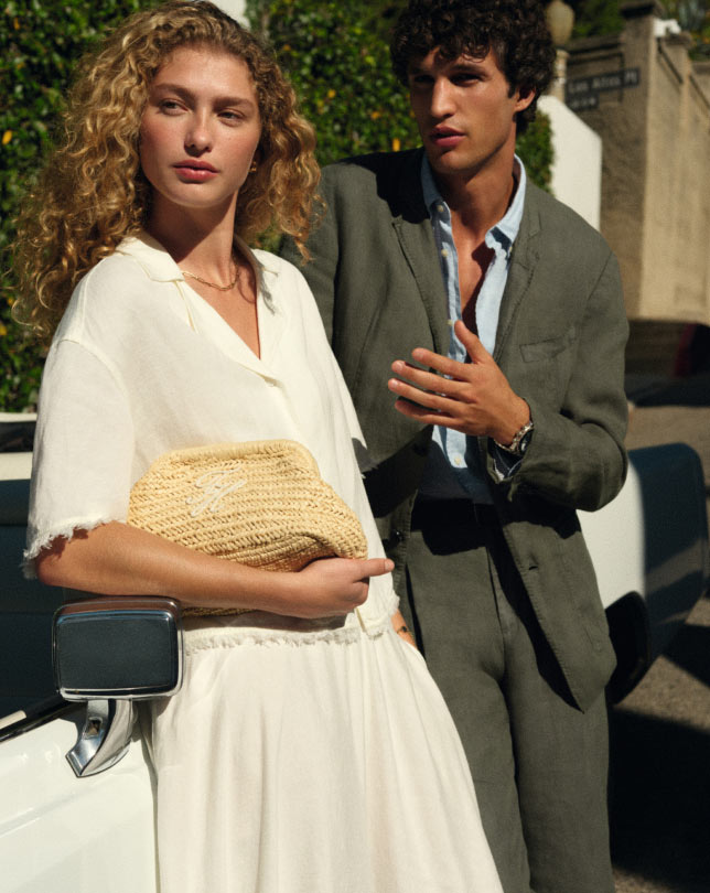 A couple sitting at a table wearing Tommy Hilfiger products