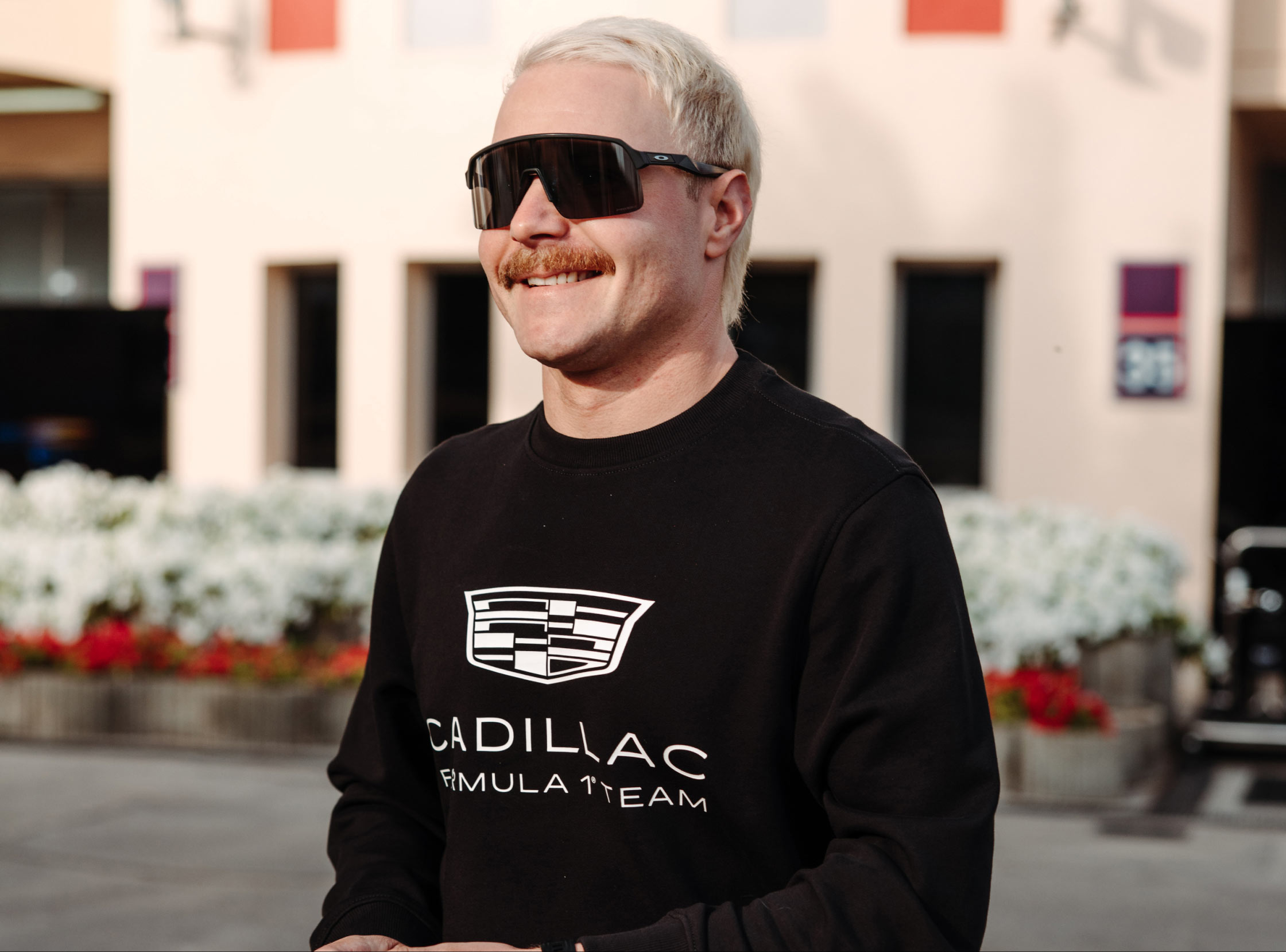 Valtteri Bottas wearing Tommy Hilfiger x Cadillac clothing.