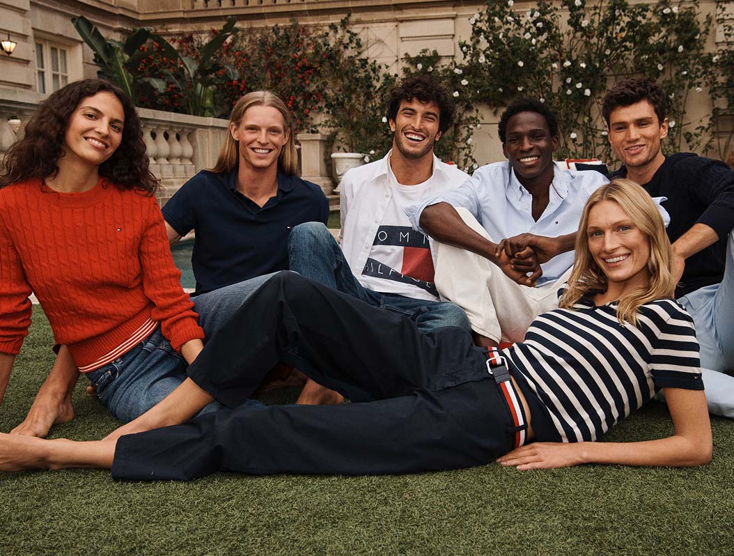 Group of models in the grass wearing Tommy Hilfiger.