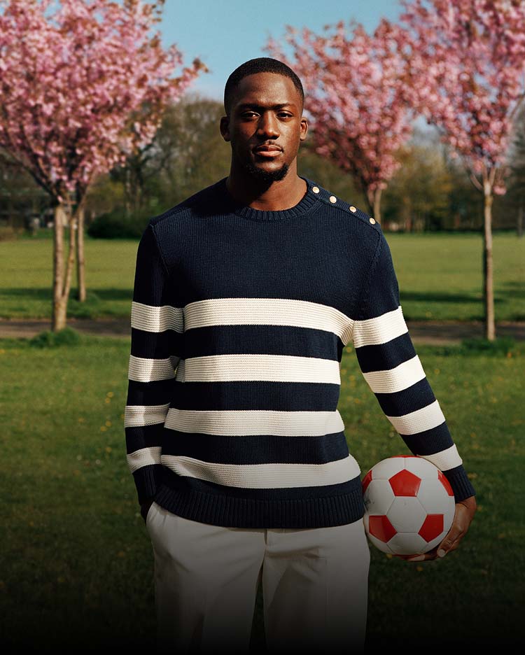 Liverpool player Ibrahima Konate wearing Tommy Hilfiger with a red background.