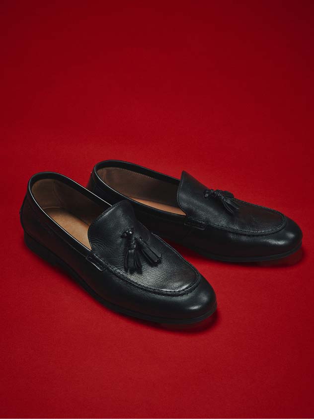 Tommy Hilfiger loafers on a red background.
