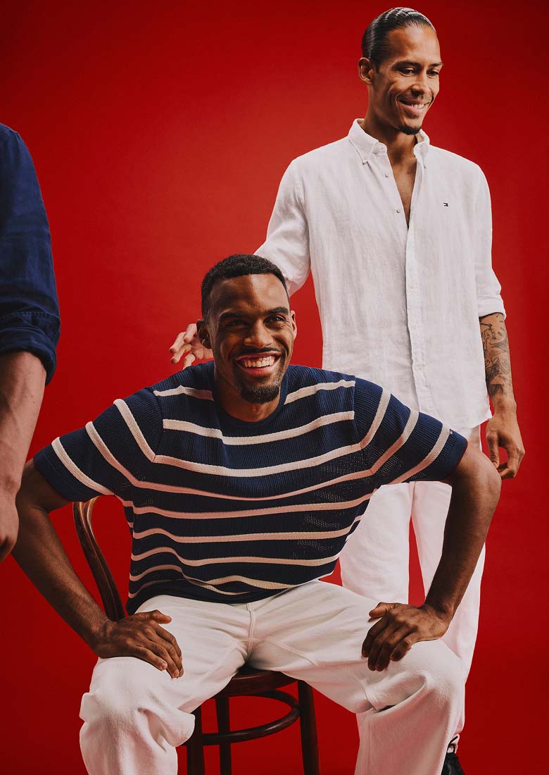 Liverpool players posing on a red background wearing Tommy Hilfiger.