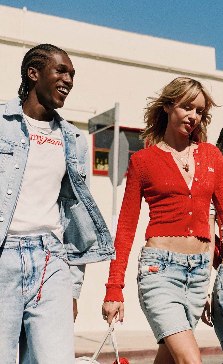 Two models walking outdoors wearing casual Tommy Jeans denim and seasonal clothing.