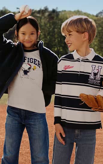 Child wearing a Tommy hilfiger navy hoodie over a graphic T-shirt.