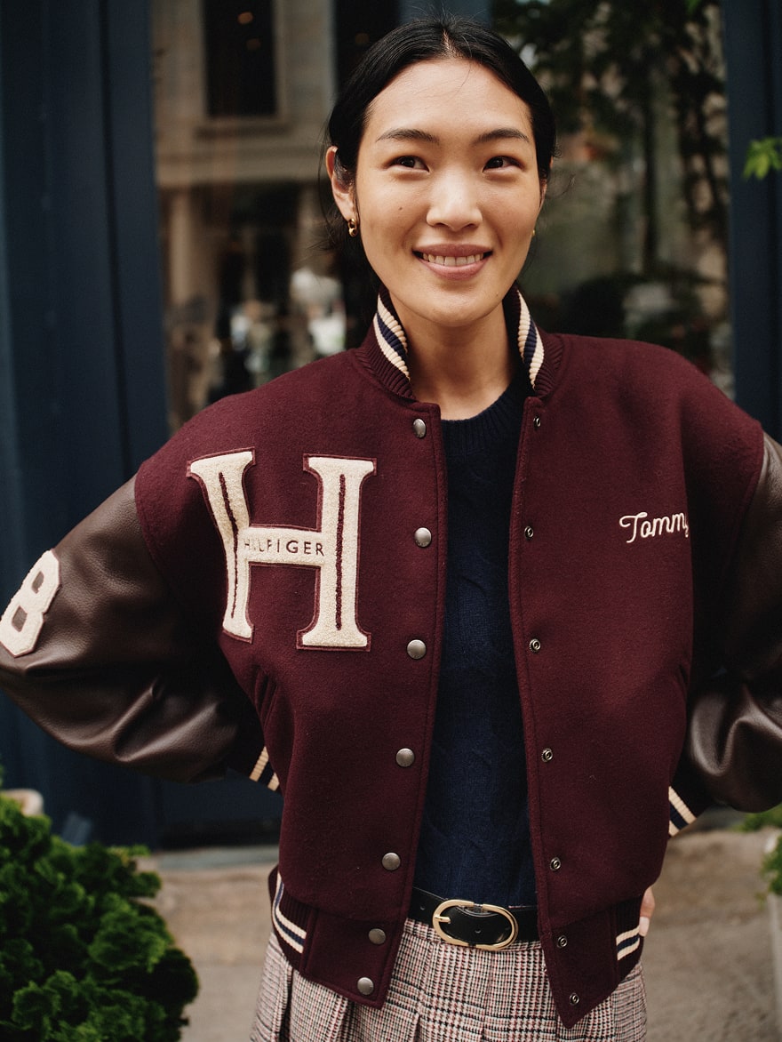 Model wearing a Tommy Hilfiger varsity jacket
