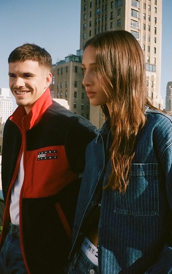 Two young models wearing Tommy Jeans outerwear in an urban setting.