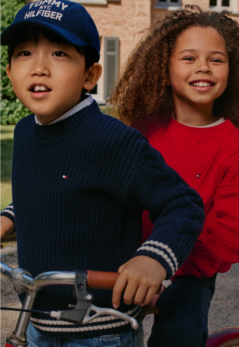 Two kids wearing a Tommy Hilfiger outfit.
