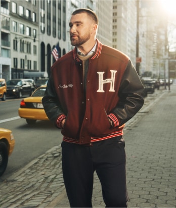 Travis Kelce Wearing a Tommy Hilfiger varsity jacket.