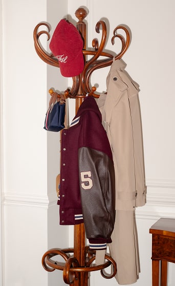 A Tommy Hilfiger Jackst and Trensh hanging on a coat rack.