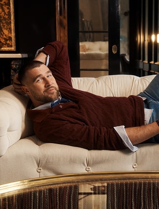 Travis Kelce wearing a Tommy Hilfiger sweater in the Plaza Hotel.