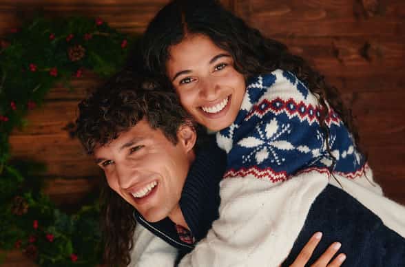 Two models wearing Tommy Hilfiger cozy sweaters.
